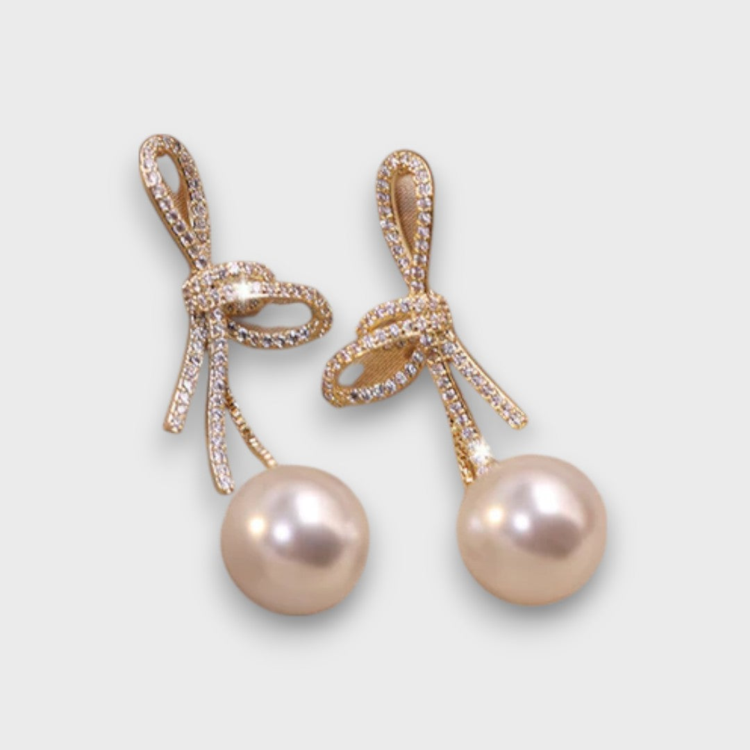 Celinea – Ohrringe mit goldenem Schleifchen und leuchtender Perle